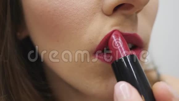 涂口红的女人化妆正在进行中女人涂红唇膏女执手管口红慢动作视频的预览图