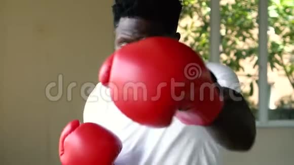 穿着红色拳击手套的非裔美国运动员在运动中攻击在健身房打拳击的男拳击手视频的预览图