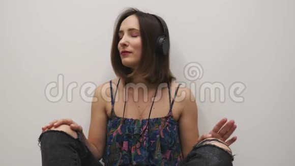女音乐家用耳机听音乐戴着耳机欣赏这首歌的女人音乐乐器概念视频的预览图