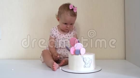 可爱的小女孩触摸香草蛋糕与粉红色和紫色装饰同时坐在粉彩背景视频的预览图