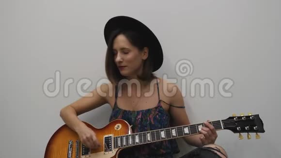 女人用电吉他演奏乡村风格的音乐音乐乐器的概念女吉他练习视频的预览图