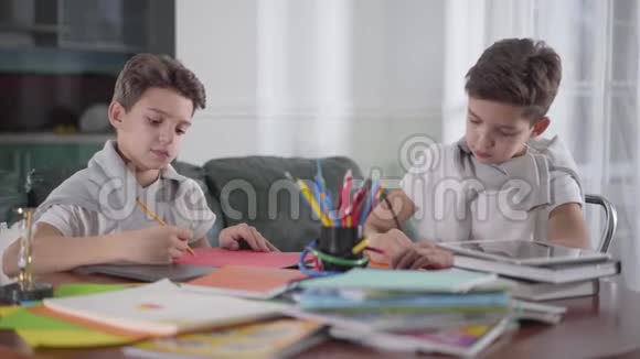 两个聪明的高加索双胞胎兄弟在家用彩色铅笔画画学生们一起做作业创意创意视频的预览图