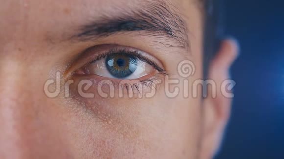 特写宏观蓝色男子的眼睛在蓝色背景半面肖像特写视频的预览图