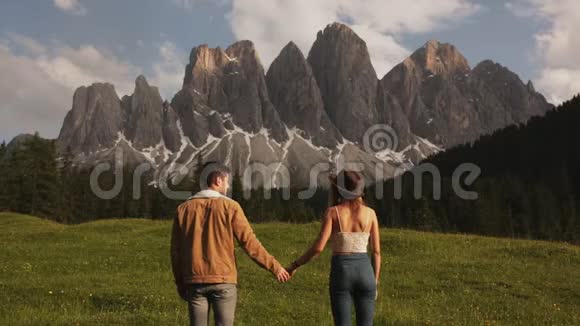 旅行者夫妇在意大利白云石上欣赏令人惊叹的山景暑假旅游和活动视频的预览图