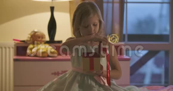 白种人女孩用红色的蝴蝶结关闭棺材拥抱她的礼物在前台关门一个小孩视频的预览图