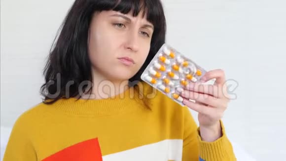 一个女人手里拿着一个水泡手里拿着药丸在网上药店里用她的一个应用程序购物视频的预览图