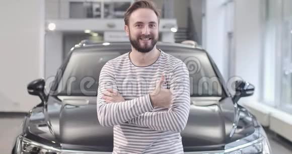 戴着脱光衣服的白人男子在新车前露出大拇指的肖像满意的买家视频的预览图