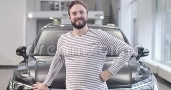 一个穿着黑色新车摆姿势的脱光毛衣的快乐白种人成功人士买车视频的预览图