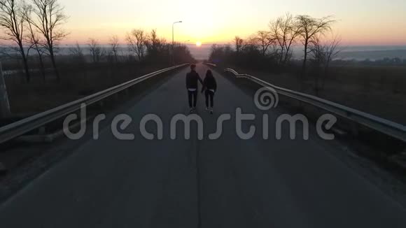 空中射击一男一女拥抱黎明时分前往城市慢镜头视频的预览图
