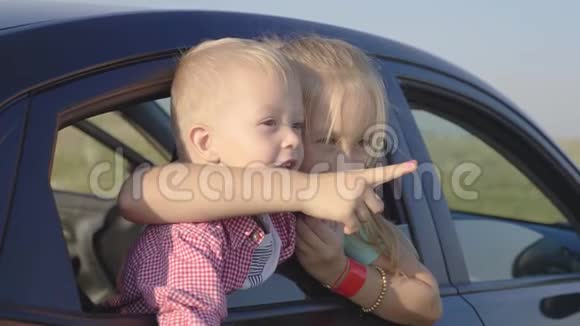 姐姐和她的弟弟望着车窗外的一辆车微笑着旅行概念视频的预览图