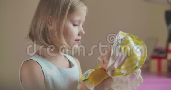 白种人女孩在室内玩娃娃的肖像穿着优雅服装的漂亮金发孩子周末视频的预览图