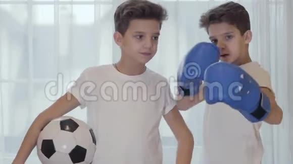 两个白种人双胞胎兄弟的肖像黑发戴着球和拳击手套年轻的小学生视频的预览图