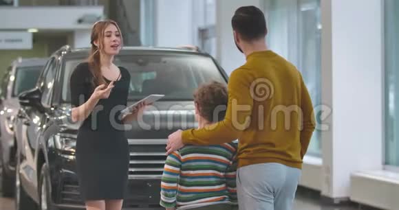 年轻自信的高加索女人向男性客户解释汽车规格成人选择新的视野视频的预览图