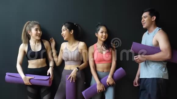 快乐微笑的男人和女人在健身房里看着相机亚洲年轻人在健身房放松后视频的预览图