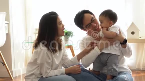 亚洲三口之家快乐年轻的爸爸和妈妈在家和小男孩一起玩游戏和拍手视频的预览图