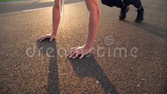 4K仍然是年轻的健身男子做俯卧撑在早晨户外在道路上日落与强烈的太阳耀斑视频视频的预览图