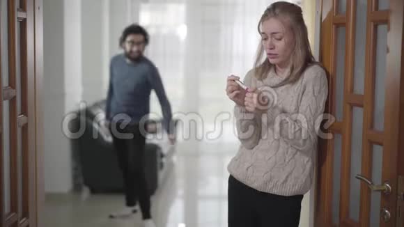 恐惧的白种人女人拿着怀孕测试用手隐藏头部她的丈夫或男友对视频的预览图