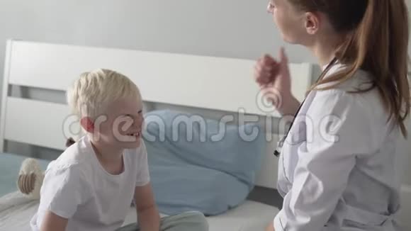 一位医生和一个男孩在医院里坐着修理时的愉快问候视频的预览图