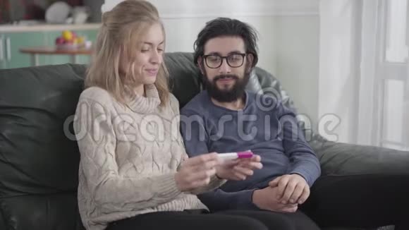 白种人金发女子的特写显示她的男朋友或丈夫肯定怀孕测试拥抱女孩的男人视频的预览图