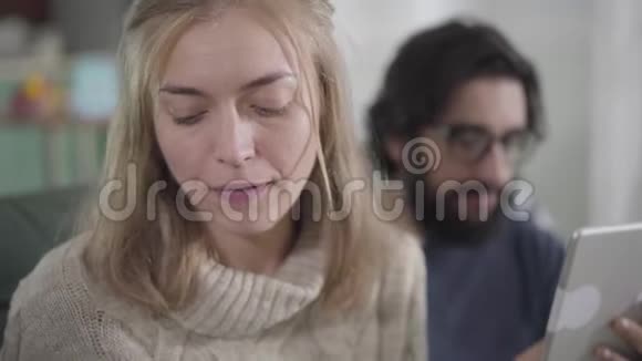 一张可怕的高加索女人的特写照片她正看着她的丈夫用平板电脑在视频的预览图