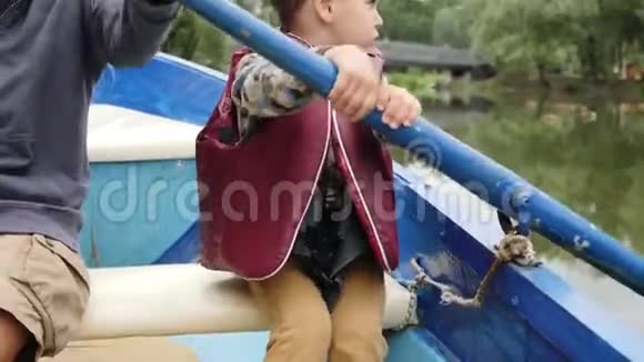孩子们的手握着木桨近距离观看小孩子手拿着桨可爱的小男孩在湖上划船视频的预览图