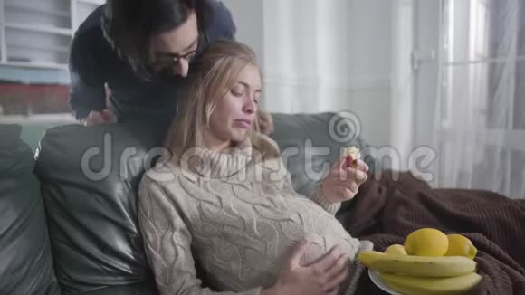 英俊的白人男人走到他怀孕的妻子面前亲吻她年轻的女人对她大吼大叫视频的预览图