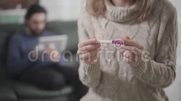 白种人年轻女性的特写双手拿着妊娠试验放在胸部一个满脸胡须的人视频的预览图