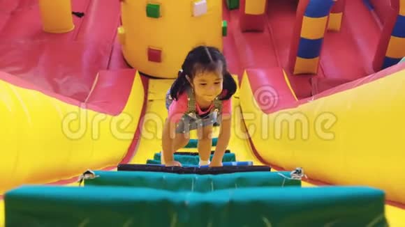 孩子们在庙会上玩空中城堡四岁的女孩正在爬坡墙到墙顶孩子们喜欢空中城堡视频的预览图