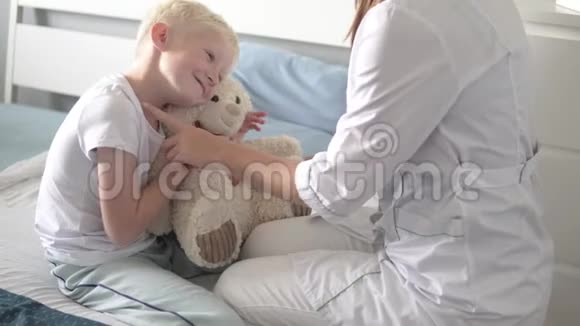 医生用听诊器听病人和他的泰迪熊视频的预览图