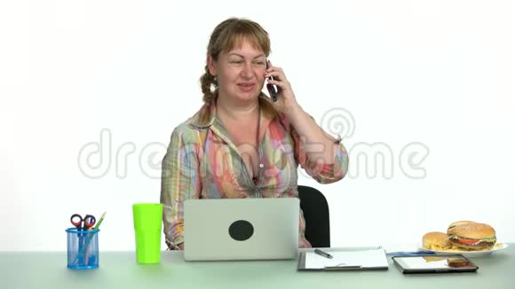一位性格开朗的办公室女性坐在工作场所打电话视频的预览图