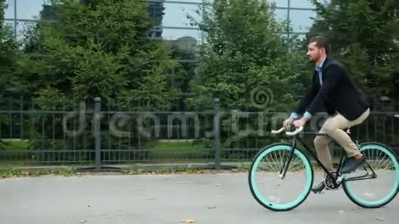 健康的成年男子骑着自行车在充满商业气息的城市街道工作视频的预览图