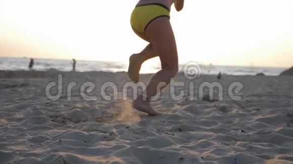 可爱的小女孩在热带海滩上奔跑快乐的孩子在美丽的夕阳下奔跑的剪影孩子的脚视频的预览图