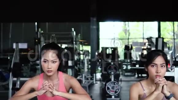 一群穿着运动服的亚洲年轻人在健身房蹲着锻炼视频的预览图