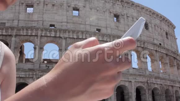 手持年轻的白种人女游客用手机在美丽的欧洲古城风景上发短信视频的预览图