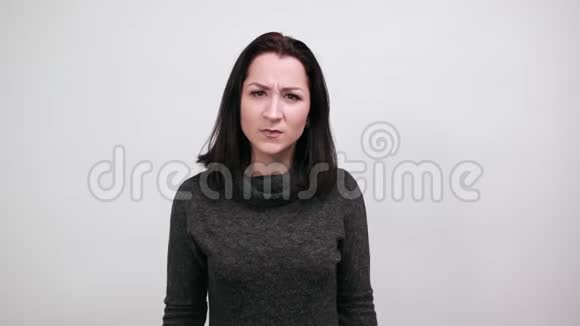 穿着黑色毛衣的不高兴的女人指着相机看上去很生气视频的预览图