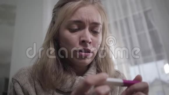 正在哭泣的白人妇女举行怀孕试验的特写照片不高兴怀孕的少女视频的预览图