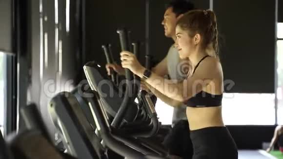 有吸引力的亚洲健身妇女在健身房使用椭圆教练健康和减肥的生活方式视频的预览图