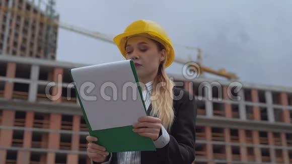 商务女性戴着安全帽将施工进度与计划进行比较女孩对结果很满意视频的预览图
