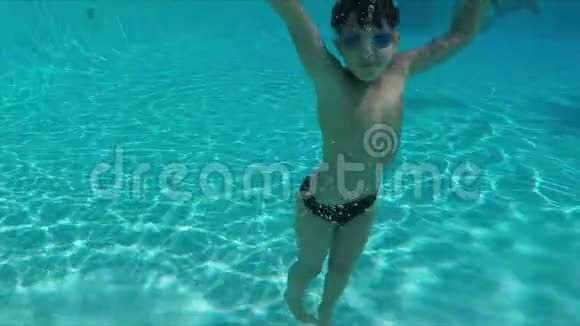 男孩潜入游泳池跳着快乐的舞蹈视频的预览图