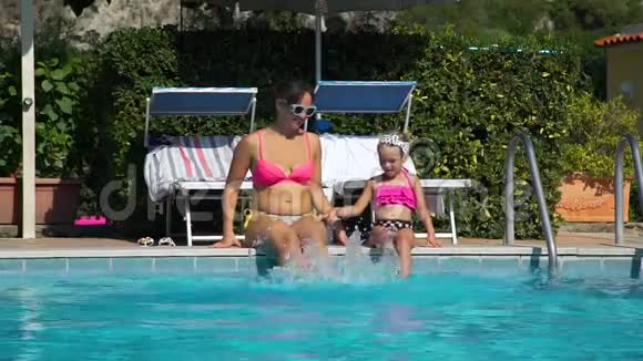 母亲和女儿在游泳池附近玩视频的预览图