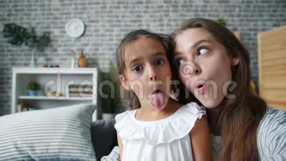 有趣的女人和女孩妈妈和女儿做滑稽的脸自拍视频的预览图