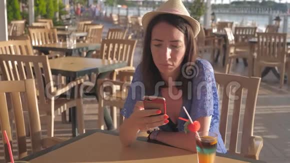 带着手机戴帽子的年轻美女旅游暑假概念视频的预览图