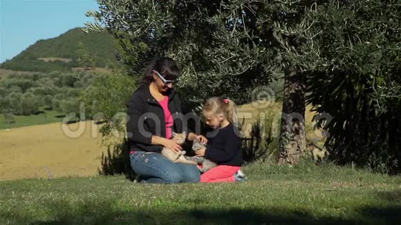 女人和女儿在户外玩小猫视频的预览图