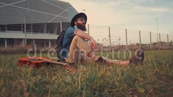带着吉他长胡子的帅哥在公园休息视频的预览图