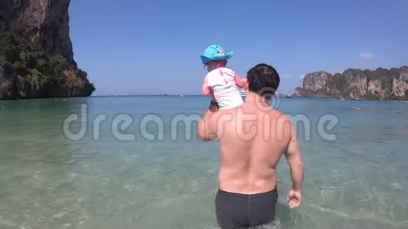 一位父亲肩上扛着一个小女儿走进大海宝宝第一次看到大海视频的预览图
