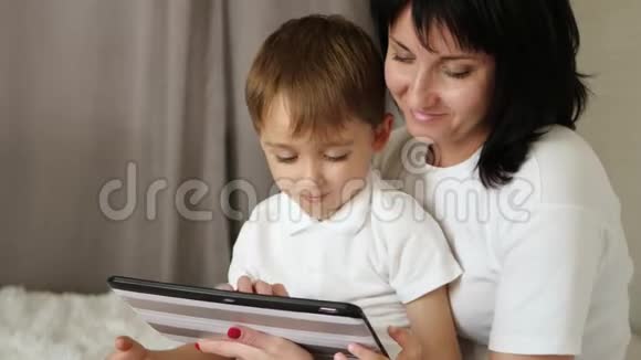 一对幸福的母子用平板看电影视频的预览图