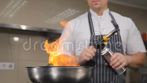 厨师在餐厅厨房做饭用火焰烹饪从煎锅中升起火焰的慢动作镜头Hd视频的预览图