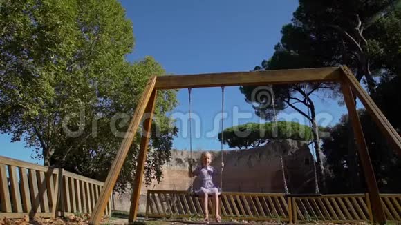 古罗马建筑附近的小女孩秋千视频的预览图