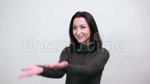 美丽的女人穿着黑色毛衣双手指向远方微笑着视频的预览图