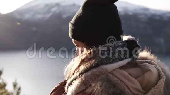 冬日里穿着外套的微笑女人在冬日里特写肖像直勾勾地望着天边背景令人惊叹视频的预览图